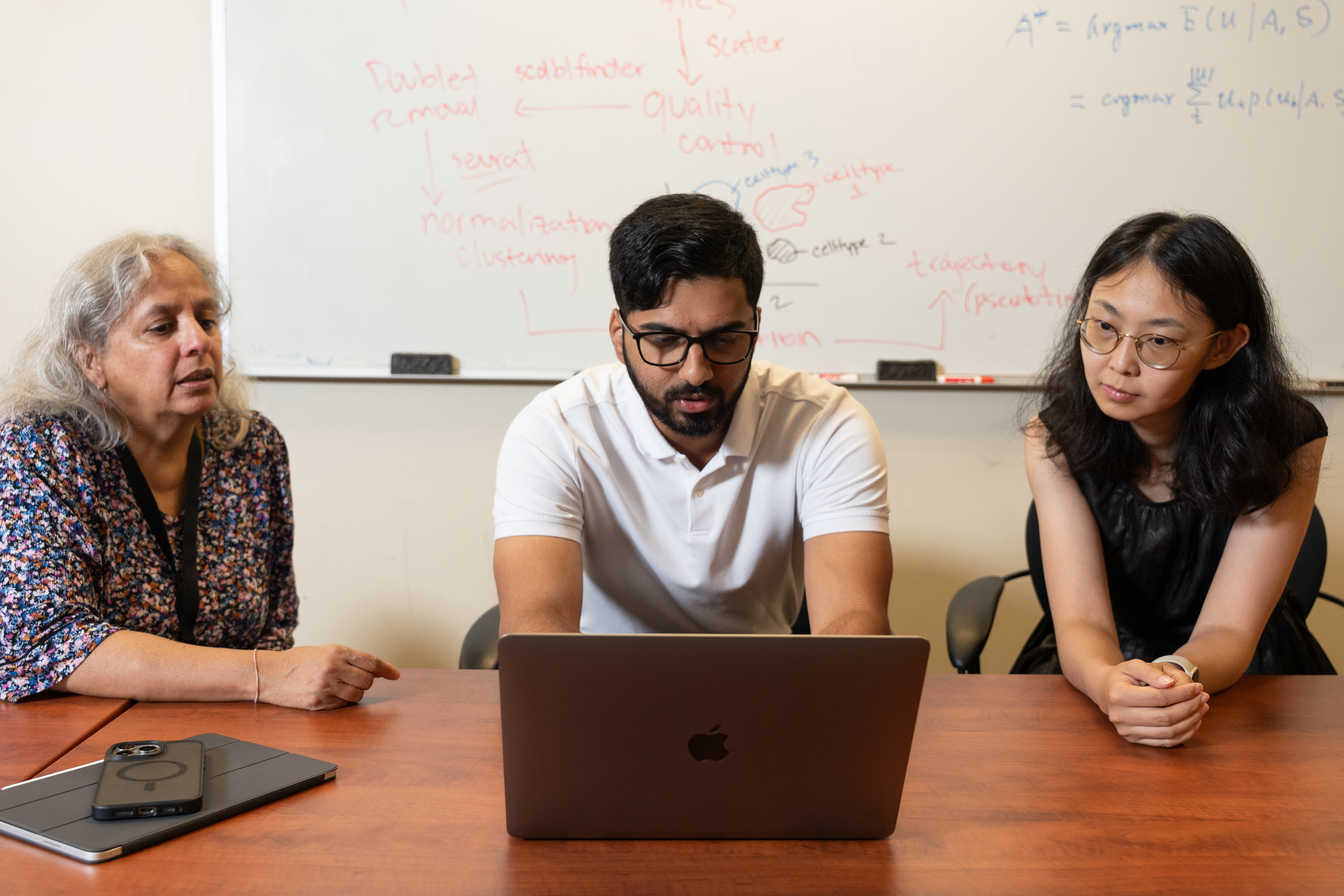 people sitting a desk looking at a computer